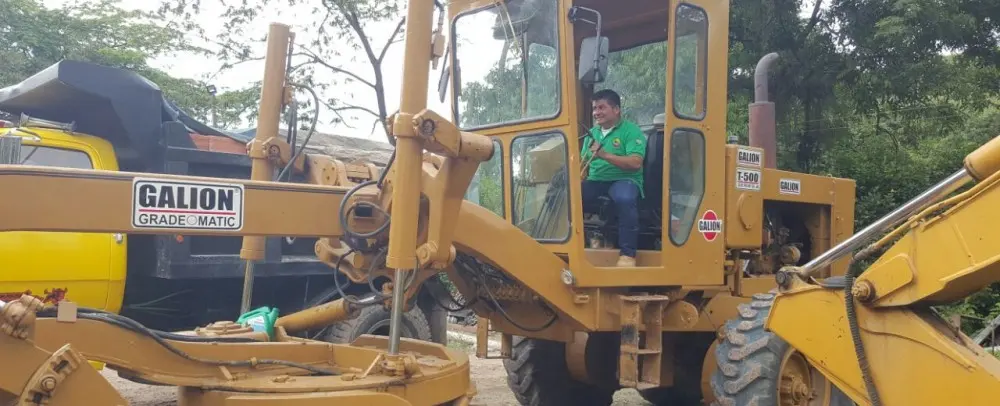 Estudiante opera una motoniveladora en el patio de máquinas