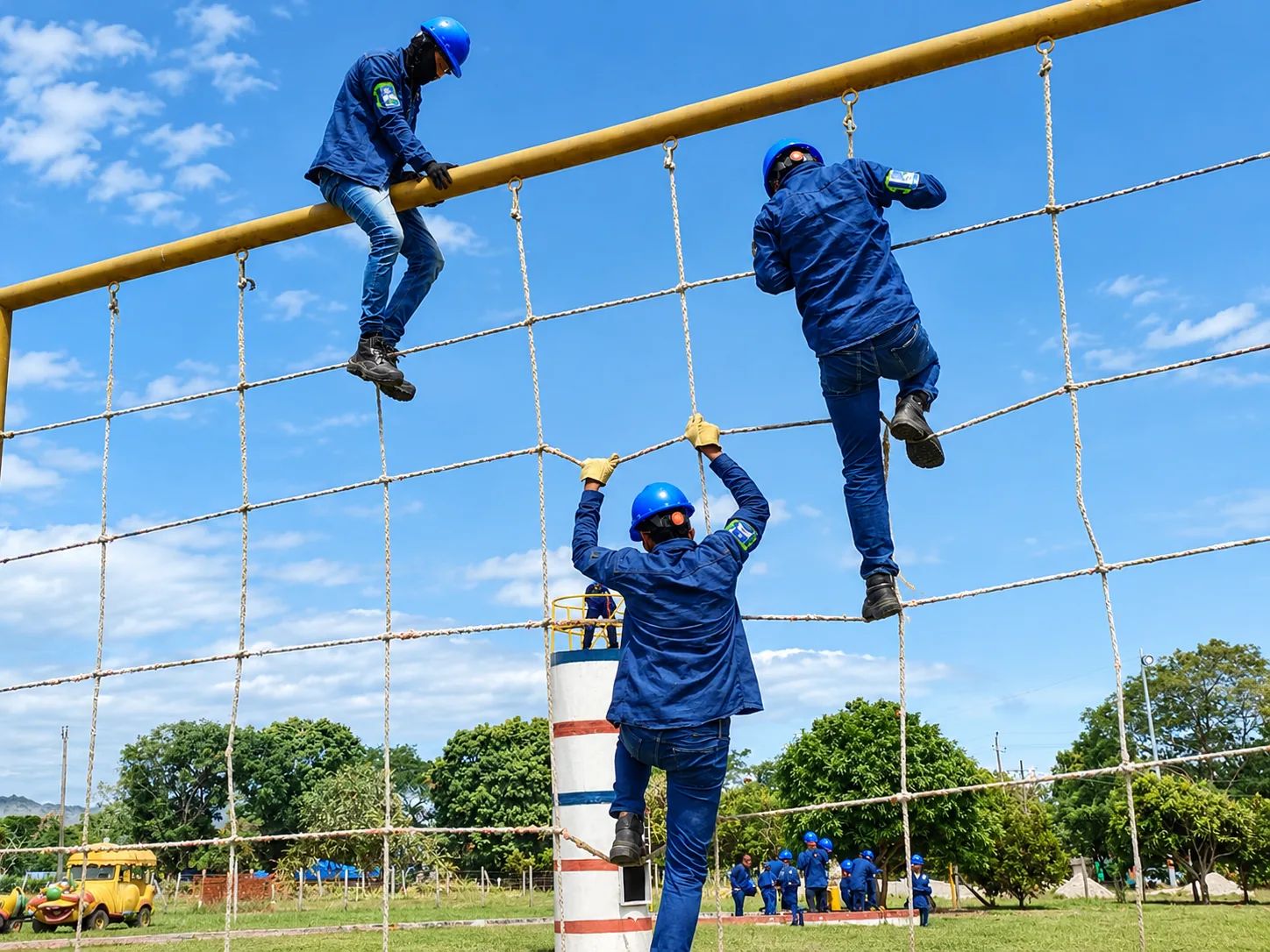 Estudiantes con casco suben por la red de cuerdas en el entrenamiento de trabajo en alturas