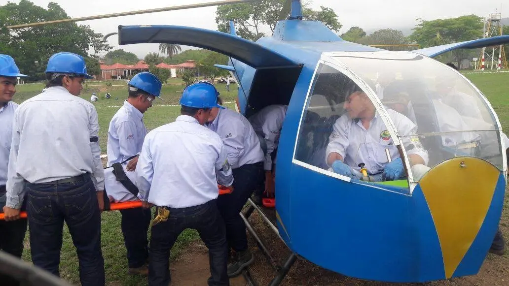 Estudiantes practican el traslado de una persona en camilla desde una cabina de helicóptero de entrenamiento